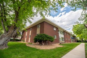 Lakewood apartment for rent - A red brick building with a green lawn in front.