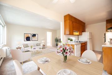 Littleton apartment for rent - A dining room with a table set for two and a kitchen area in the background.