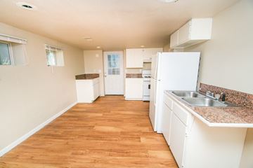 Denver apartment for rent - a kitchen with white cabinets and a sink and a refrigerator