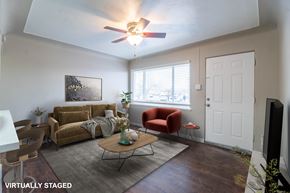 Edgewater apartment for rent - A living room with a brown couch, a red chair, and a coffee table.