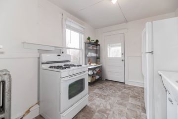 Denver apartment for rent - A white kitchen with a stove and a refrigerator.