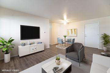 Denver apartment for rent - A living room with a grey couch, a white coffee table, and a television on the wall.