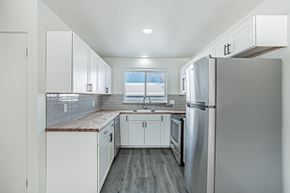 Wheat Ridge apartment for rent - A kitchen with white cabinets and a stainless steel refrigerator.