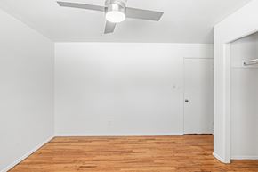 Wheat Ridge apartment for rent - A room with a ceiling fan and wooden flooring.