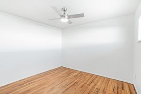 Wheat Ridge apartment for rent - A room with a ceiling fan and wooden flooring.