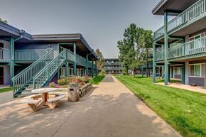 Greeley apartment for rent - a sidewalk between two buildings with a picnic table