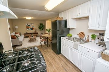 Denver apartment for rent - A kitchen with a black refrigerator and white cabinets.