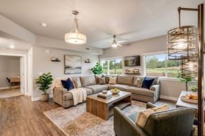 Fort Collins apartment for rent - A well-lit living room with a large couch, a coffee table, and a floor lamp.