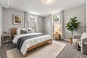 Denver triplex for rent - A bedroom with a large bed and a plant.