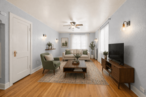 Denver apartment for rent - A living room with a green chair, a white sofa, and a wooden coffee table.
