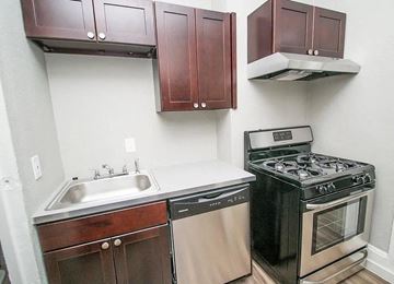 Denver apartment for rent - A kitchen with a black stove and a white sink.