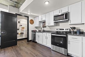 Greeley apartment for rent - A kitchen with black and white cabinets and a black refrigerator.