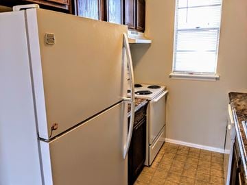 Lafayette triplex for rent - a kitchen with a refrigerator and a stove and a window