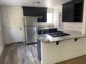 Denver apartment for rent - A kitchen with a refrigerator, cabinets, and a stove top oven.