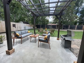 Boulder triplex for rent - A patio with a table and chairs under a pergola.