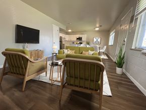 Boulder triplex for rent - A living room with two green chairs facing a television.
