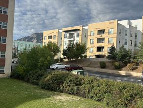 Boulder apartment for rent - A car is parked on the side of a road in front of a building.