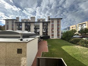 Boulder apartment for rent - A modern building with a flat roof and a green lawn in front.