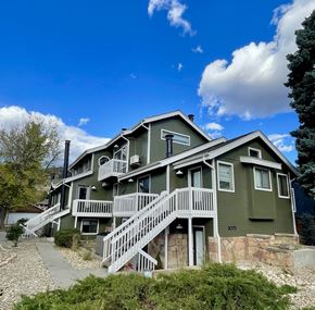 Boulder apartment for rent - a green house with white stairs and a blue sky