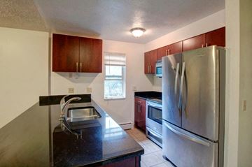 Boulder apartment for rent - a kitchen with stainless steel appliances and black counter tops