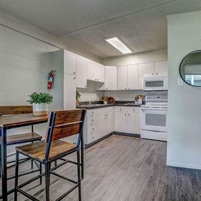 Greeley apartment for rent - a kitchen with white cabinets and a table and chairs