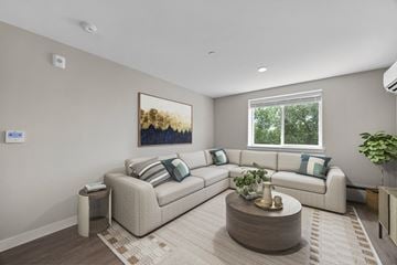 Englewood apartment for rent - A living room with a large couch, a coffee table, and a painting on the wall.