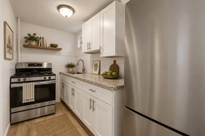 Denver townhouse for rent - A modern kitchen with a stainless steel refrigerator and white cabinets.