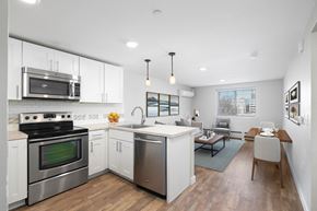 Englewood apartment for rent - a kitchen and living room with white cabinets and stainless steel appliances