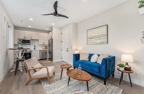 Denver apartment for rent - A living room with a blue couch, a wooden chair, and a coffee table.