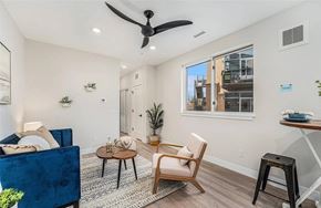 Denver apartment for rent - A living room with a blue couch, a wooden chair, and a coffee table.