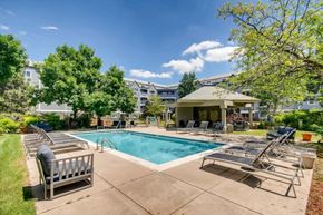 Boulder apartment for rent - A pool area with sun loungers and a building in the background.