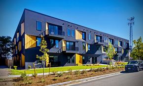 Denver apartment for rent - A modern apartment building with balconies and a car parked in front.