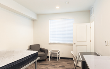 Greeley apartment for rent - A bedroom with a bed, chair, and table.