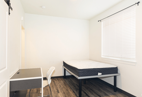 Greeley apartment for rent - A bedroom with a bed, desk, and chair.