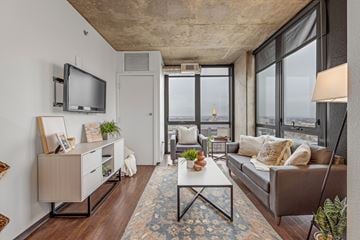 Denver apartment for rent - A living room with a brown couch and a television on the wall.