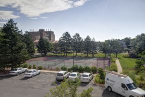 Boulder apartment for rent - a parking lot with cars and a tennis court in front of a building