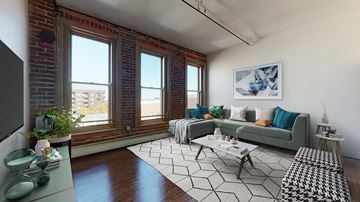 Denver apartment for rent - A living room with a green couch and a black and white rug.