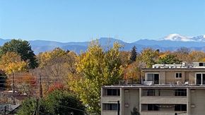 Denver apartment for rent - the view of the snow capped mountains from the roof of a building