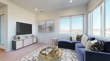 Denver apartment for rent - A living room with a blue couch and a television.