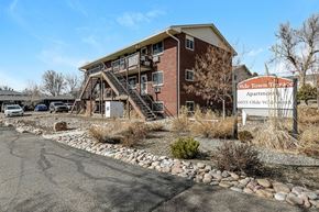 Arvada apartment for rent - A large brick building with a sign that says "Olde Town Apartments" in front of it.
