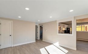 Denver apartment for rent - A spacious room with a white door and a window with blinds.