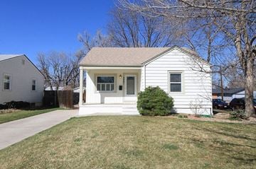 Denver apartment for rent - A white house with a brown roof and a small front yard.