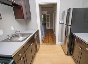 Denver apartment for rent - A kitchen with a sink, refrigerator, and wooden floors.