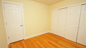 Denver apartment for rent - a bedroom with three closets and a wood floor