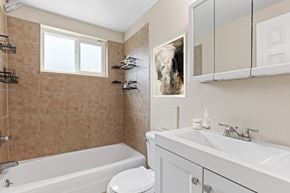 Englewood apartment for rent - A bathroom with a white tub, sink, and toilet.