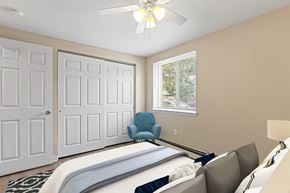 Englewood apartment for rent - A bedroom with a bed, chair, and two doors.