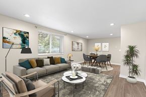 Englewood apartment for rent - A modern living room with a grey sofa, a coffee table, and a dining table with chairs.