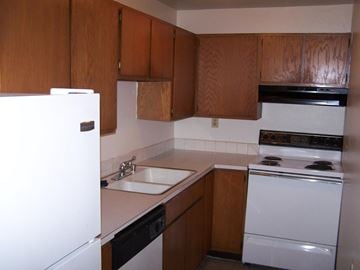 Greeley apartment for rent - A kitchen with brown cabinets and white appliances.