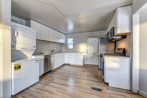 Denver apartment for rent - A kitchen with white appliances and wooden floors.