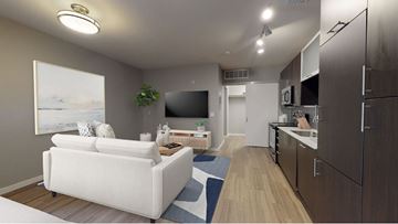 Denver apartment for rent - A modern living room with a white couch and a television.